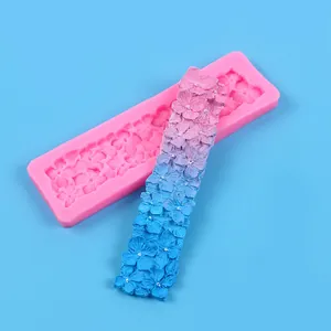 Pink silicone floral lace mold for fondant shown with gradient flower strip sample