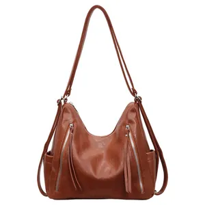 Full view of brown faux leather hobo bag with multiple decorative silver zippers
