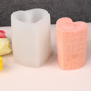 Close-up van een hartvormige siliconen mal naast zijn roze love-kaars
