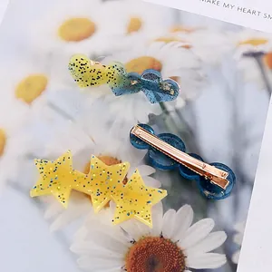 Vue détaillée de barrettes à cheveux en résine pailletée colorée en forme de cœur