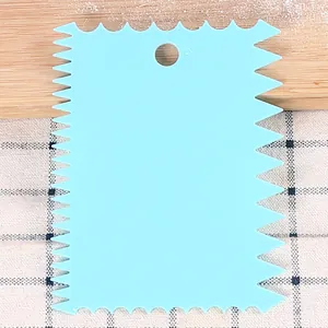Close-up detail view of a light blue serrated plastic cake scraper tool for DIY baking