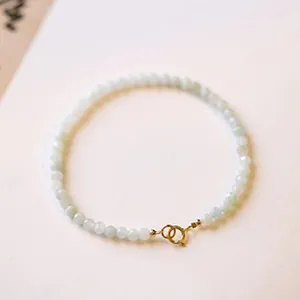 Nahaufnahme eines minimalistischen facettierten Perlenarmbands mit goldenem Federverschluss