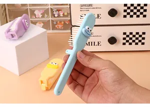 Macro view of a portable light blue foldable mini hair comb with a cute cartoon face