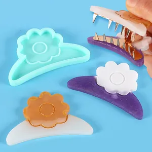 Silicone mold for DIY hair clips featuring flower-shaped resin designs on blue background