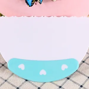 Primer plano de un raspador de pasteles de plástico blanco con borde ondulado y mango azul