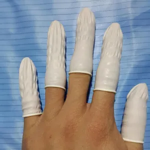 Macro view of white disposable latex finger cots with non-slip texture for beauty protection