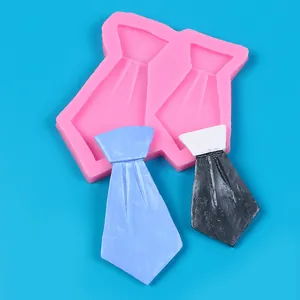 Detailopname van roze siliconen mal voor stropdassen met afgewerkte fondant stropdassen