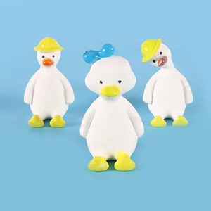 Set aus drei Miniatur-Entenfiguren in Weiß mit gelben Hüten und einer blauen Schleife