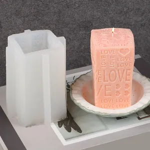 Detail van vierkante siliconen mal en afgewerkte roze kaars met hart- en liefdespatronen