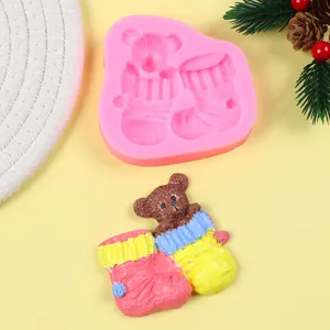 Detailansicht der rosa Silikonform für Weihnachtsbär-Socken und buntes DIY Bastelergebnis.