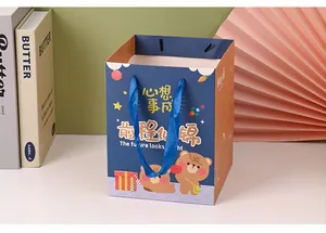 Close-up of a cartoon birthday gift bag with cute bear designs and blue ribbon handles.
