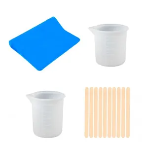 Epoxy resin tool kit including silicone mat, measuring cups, and wooden stir sticks.