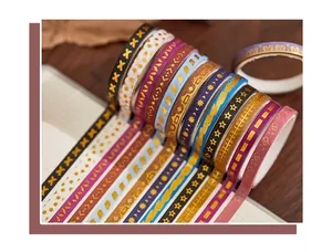 Close-up of decorative washi tape set featuring elegant gold foil geometric patterns