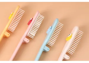 Detail of cute cartoon foldable mini combs with soft white bristles in pastel colors
