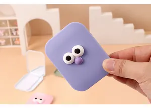 Close-up of cute purple portable folding makeup mirror with cartoon 3D eye design