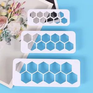 Close-up of three white hexagonal honeycomb geometric plastic cake cutters