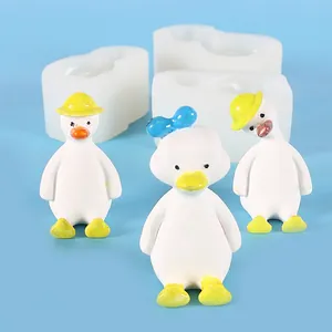 Detailansicht von Enten-Silikonformen und weißen Enten-Ornamenten auf blauem Hintergrund.