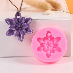 Detail view of a pink flower silicone mold and its purple resin pendant creation.