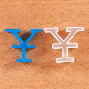 Yen symbol silicone mold and blue glitter resin ornament on wood surface