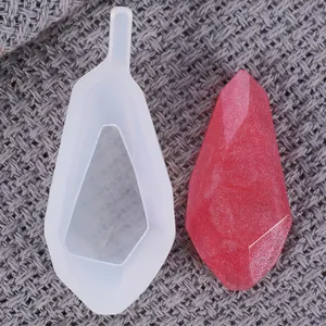 Detail view of a diamond-shaped silicone resin mold with a finished red crystal pendant