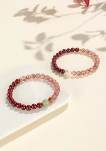 Detail shot of red cinnabar and southern red agate beaded bracelets on a white plate