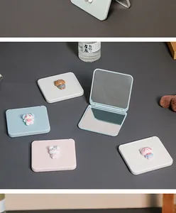 Detailed view of cute portable cartoon folding makeup mirrors in soft pastel colors.