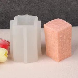 Detailweergave van de siliconen mal naast een afgewerkte kaars met 'LOVE' reliëfpatroon