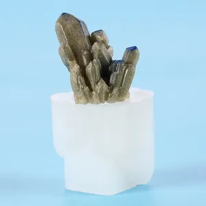 Macro view of DIY silicone mold showing finished resin crystal cluster on blue background