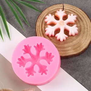 Detailed view of a pink silicone snowflake mold with a finished decorative piece.