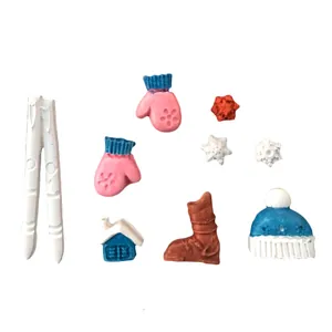 Close-up of various Christmas-themed fondant decorations including mittens and skis
