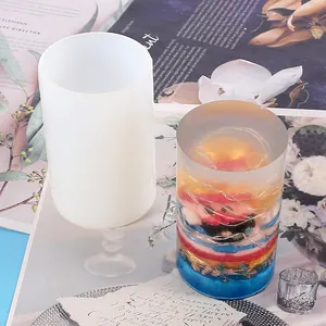 Detail view of a cylindrical silicone mold next to a decorative floral epoxy resin candle holder.