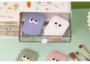 Macro view of colorful portable makeup mirrors with cute cartoon eyes in a desk drawer