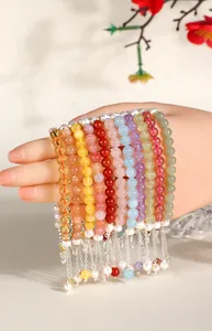 Detailed view of colorful gemstone bracelets featuring freshwater pearls and butterfly charms