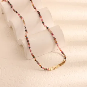 Dettaglio di una collana di perle in pietra naturale multicolore con inserti in metallo oro