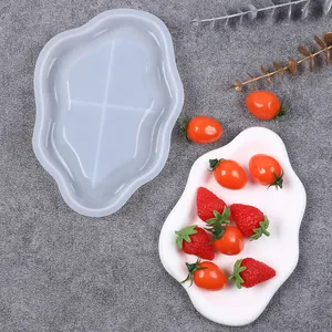 Detail view showing a cloud-shaped silicone mold alongside a finished white resin tray