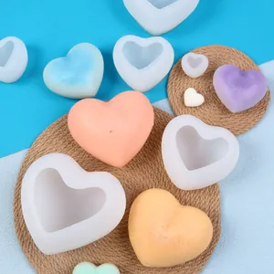 Vue détaillée de divers moules en silicone coeur 3D avec des bougies parfumées colorées
