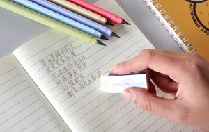 Detailed shot of an inkless everlasting pencil and eraser used on a lined notebook