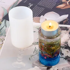 Close-up of DIY silicone mold and a finished crystal epoxy candle holder with a lit candle.