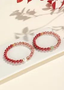 Close-up of elegant cinnabar and red agate bracelets with green jade and white pearl beads