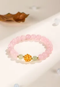 Close-up of elegant pink crystal bracelet with gold lotus charm and green jade beads