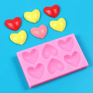Detailansicht der pinkfarbenen 6-Loch-Herz-Silikonform mit bunten Herz-Süßigkeiten