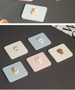Macro view of various cartoon mini portable folding mirrors decorated with cute 3D animal charms