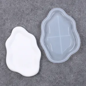 Top view of a cloud-shaped silicone tray mold and a white finished plaster tray coaster