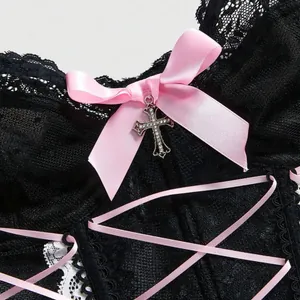 Elegante corsetto in pizzo nero con fiocco in nastro rosa e ciondolo a croce d'argento