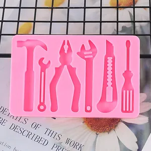 Gros plan d'un moule en silicone rose avec des formes d'outils pour décoration DIY