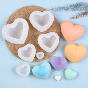 Divers moules en silicone en forme de cœur 3D avec des échantillons de bougies colorées