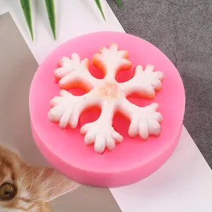 Close-up of a pink silicone mold showing a detailed snowflake shape for Christmas crafts