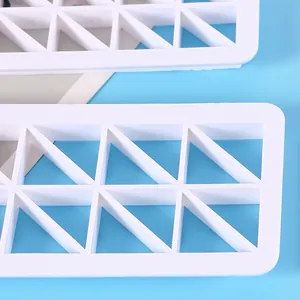 Macro detail view of white plastic geometric triangle pattern cookie cutter baking mold