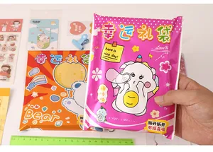 Gros plan d'une main tenant un sac cadeau surprise rose vif avec des motifs de dessins animés
