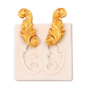 Détail d'un moule en silicone à relief de rinceaux européens vintage avec fondant doré.